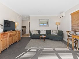 A living room with a sofa and television at Red Beach Retreat - Whangaparaoa Peninsula