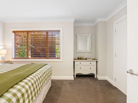 A bedroom with a bed and a dresser at Red Beach Retreat - Whangaparaoa Peninsula