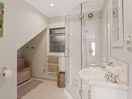 A bathroom with a shower and a sink at Red Beach Retreat - Whangaparaoa Peninsula
