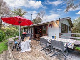 A deck with chairs and a table at Hatepe Lake Taupo Retreat in Lake Taupo