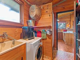 A laundry room with a washing machine and sink at Hatepe Lake Taupo Retreat, Lake Taupo