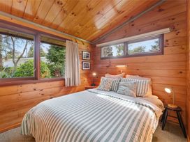 A bedroom with a bed and windows at Hatepe Lake Taupo Retreat Lake Taupo