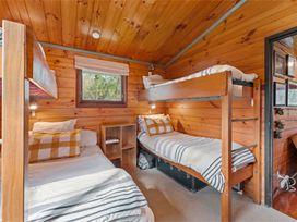 A bedroom with bunk beds and a single bed at Hatepe Lake Taupo Retreat Lake Taupo