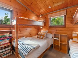 A bedroom with a bunk bed and single bed at Hatepe Lake Taupo Retreat, Lake Taupo