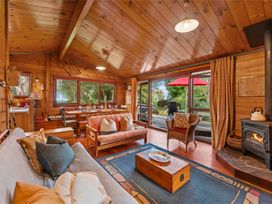 A living room with a sofa and dining table at Hatepe Lake Taupo Retreat in Lake Taupo