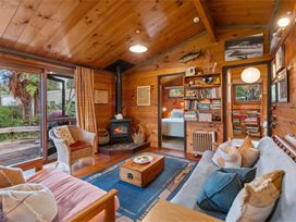 A living room with a wood stove and bookshelf at Hatepe Lake Taupo Retreat, Lake Taupo