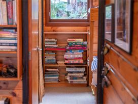 A bookshelf with books and board games in the study at Hatepe Lake Taupo Retreat Lake Taupo