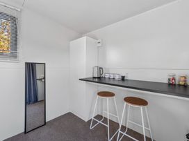A kitchen area with a counter and stools at Taupo - Holiday Home