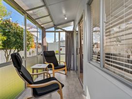 A conservatory with chairs and a table at Taupo - Holiday Home