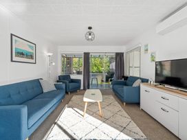 A living room with blue sofas and a coffee table at Taupo - Holiday Home
