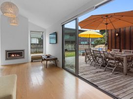 A living room with a fireplace and television leading to an outdoor deck at White Sands Haven - Omaha