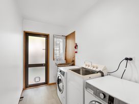 A laundry room with a washing machine and sink at Paihia in Paihia
