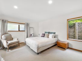 A bedroom with a bed and chair at Paihia