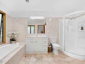A bathroom with a bathtub, sink, toilet, and shower at Paihia