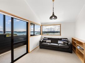 A living room with a sofa and large windows at Paihia