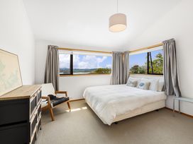 A bedroom with a bed and windows at Paihia in Paihia