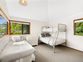 A bedroom with a bunk bed and single bed at Paihia