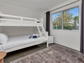 A bedroom with a bunk bed and a window at Ruakaka Coastal Reserve Retreat in Ruakaka