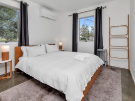 A bedroom with a bed and bedside tables at Ruakaka Coastal Reserve Retreat Ruakaka