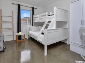 A bedroom with a bunk bed and a side table at Ruakaka Coastal Reserve Retreat in Ruakaka
