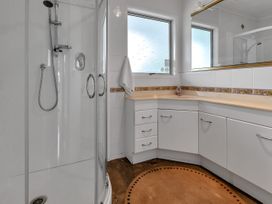 A bathroom with a shower and vanity at Ruakaka Coastal Reserve Retreat in Ruakaka