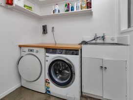 A laundry room with washing machine and dryer at Ruakaka Coastal Reserve Retreat in Ruakaka