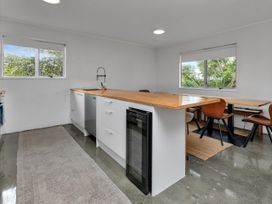 A kitchen with a countertop and dining table at Ruakaka Coastal Reserve Retreat in Ruakaka