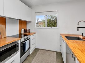 A kitchen with a stove, sink, and counter at Ruakaka Coastal Reserve Retreat, Ruakaka
