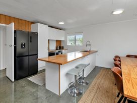 A kitchen with a refrigerator and island at Ruakaka Coastal Reserve Retreat, Ruakaka