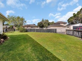 A garden with grass and a tree at Ruakaka Coastal Reserve Retreat in Ruakaka