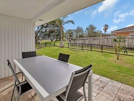 An outdoor dining area with a table and chairs at Ruakaka Coastal Reserve Retreat in Ruakaka
