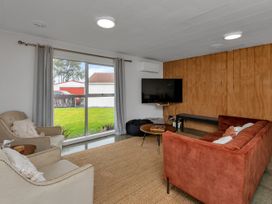 A living room with a sofa and television at Ruakaka Coastal Reserve Retreat Ruakaka