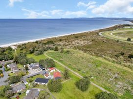 An aerial view of coastal area with houses near the beach at Ruakaka Coastal Reserve Retreat in Ruakaka