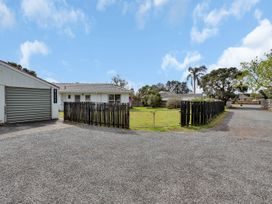 An outdoor area with a house, garage, and driveway at Ruakaka Coastal Reserve Retreat Ruakaka