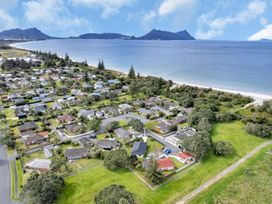 An aerial view of residential area with beach and mountains at Ruakaka Coastal Reserve Retreat in Ruakaka