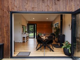 A dining room with a table and chairs at Hidden Springs Mountain View Waihi