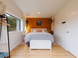A bedroom with a bed and window at Hidden Springs Mountain View Waihi