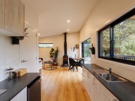 A kitchen with a stove and dining area at Hidden Springs Mountain View Waihi
