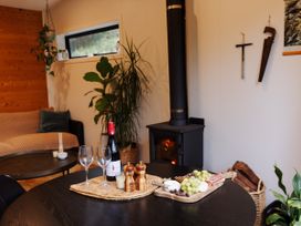 A living room with a wood stove and snack tray at Hidden Springs Mountain View Waihi