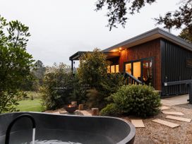 An outdoor area with a bathtub and fire pit at Hidden Springs Mountain View Waihi