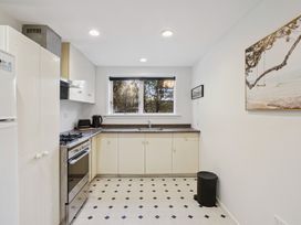 A kitchen with a sink, stove, and refrigerator at Wanaka Holiday Home in Wanaka