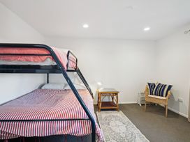 A bedroom with a bunk bed and a chair at Wanaka Holiday Home in Wanaka
