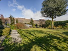A garden with grass and trees at Wanaka Holiday Home in Wanaka