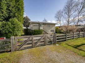 A house with a fence and gate at Wanaka Holiday Home in Wanaka