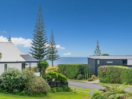 A view of houses and trees with the sea in the background at Whangamata