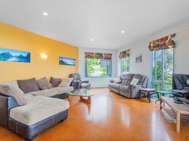 A living room with sofas and decorative windows at Whangamata in Whangamata