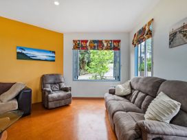 A living room with sofa and armchair at Whangamata in Whangamata
