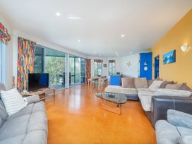 A living room with sofas and a television at Whangamata