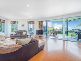 A living room with sofas and a television at Whangamata