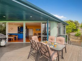An outdoor area with a dining table and chairs at Whangamata